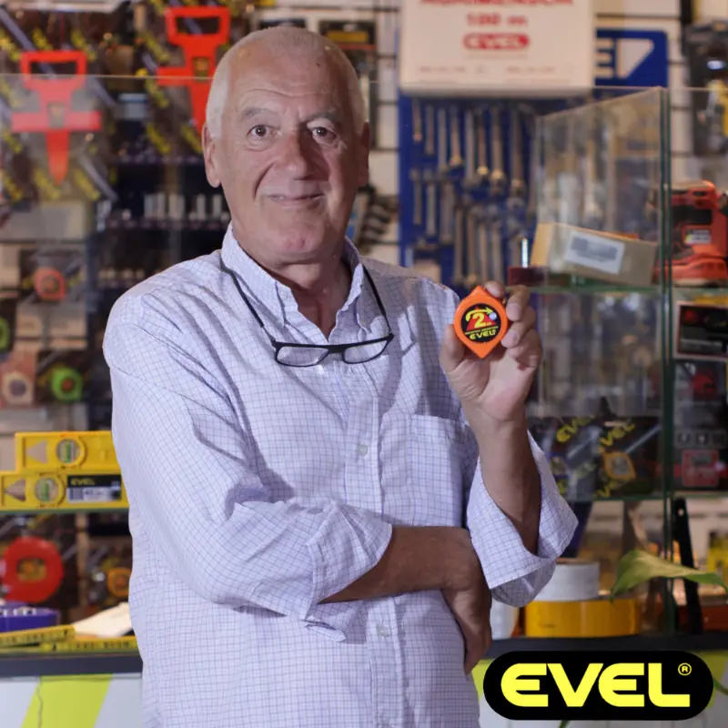 Ferretero mostrando las cintas métricas de Evel en su comercio con logo de Evel